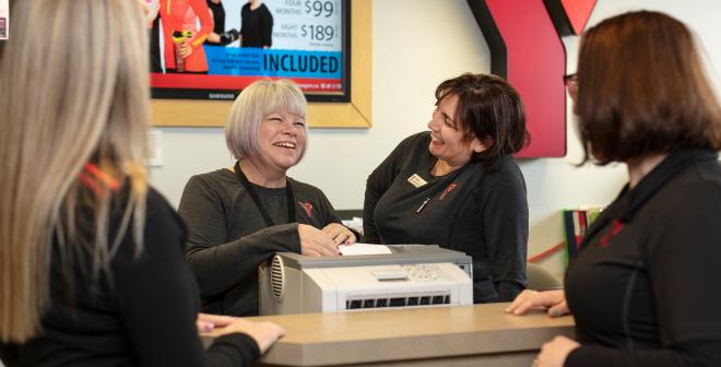 Women Smiling around the front desk