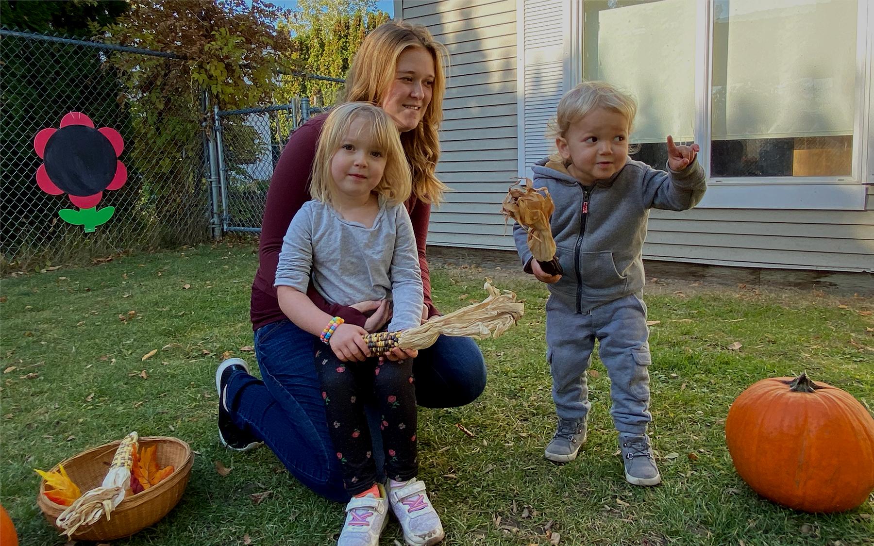 Family of 3 outside with a pumpkin